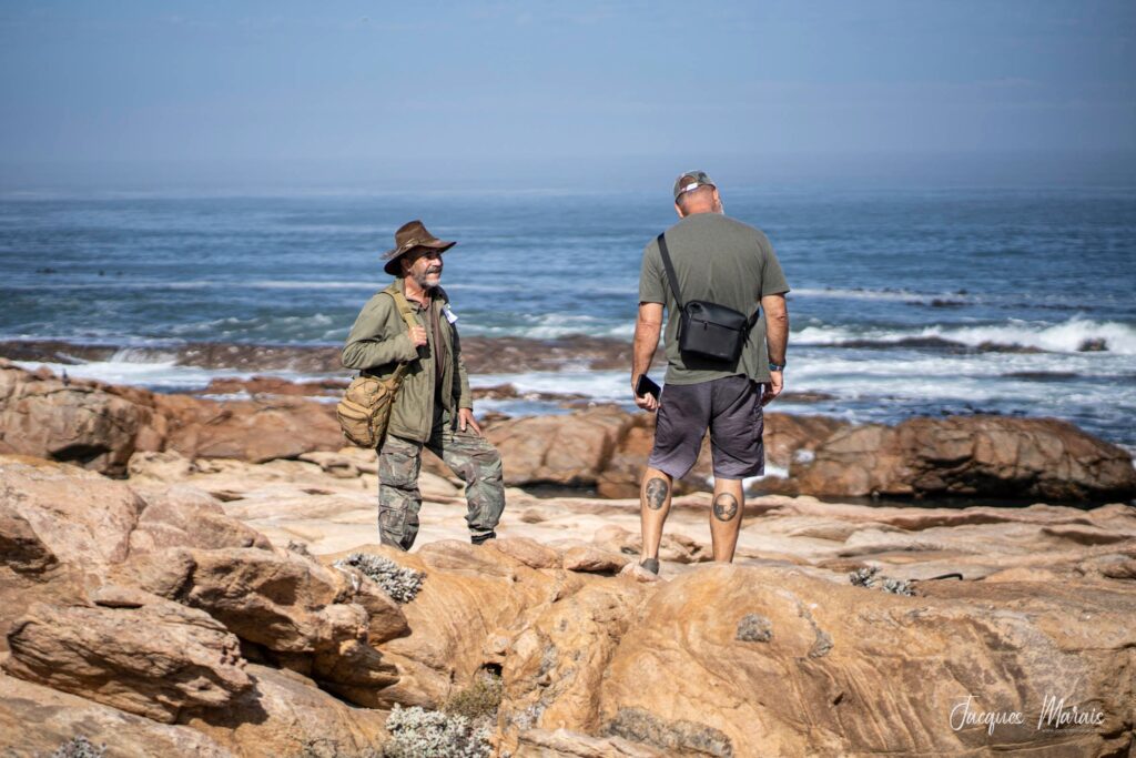 2 men talking on the rocks of West Coast